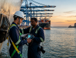 **Alt Text:** Marine & offshore inspection professionals conducting ship safety inspection at a commercial port during sunset to ensure compliance, risk prevention, and operational safety.